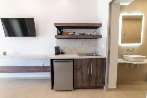 una pequeña cocina con lavabo y espejo en Lithitsa Lofts and Suites en Párga