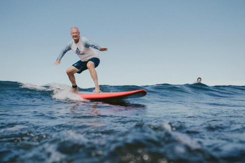 a man riding a wave on a surfboard in the ocean at Surf Synergy All-Inclusive Surf and Wellness Retreat in Jacó
