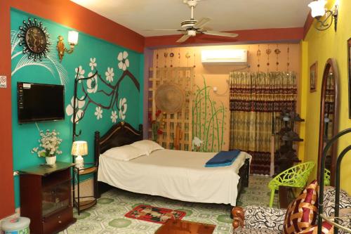 een slaapkamer met een bed en een tv. bij GREEN LEAF GUEST HOUSE in Sreemangal