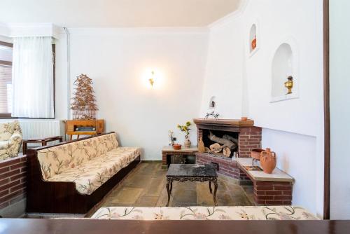 a living room with a couch and a fireplace at Villa Sofia Nea Peramos in Néa Péramos