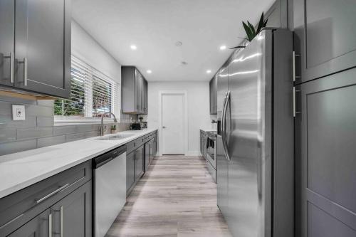 a kitchen with a stainless steel refrigerator and cabinets at Sweet Escape 5 br/2ba min from airport and beach in Fort Lauderdale