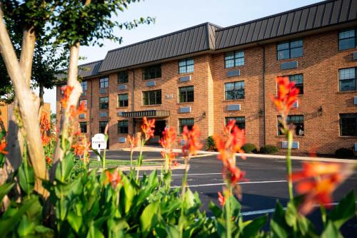 a brick building with red flowers in front of it at Patriots Inn in Williamsburg