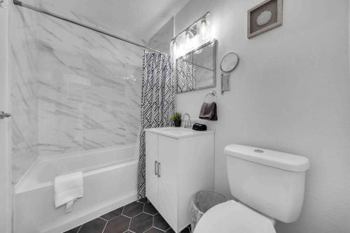 a white bathroom with a toilet and a shower at Sweet Escape 5 br/2ba min from airport and beach in Fort Lauderdale