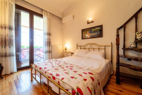 a bedroom with a bed and a large window at Villa Sofia Nea Peramos in Néa Péramos