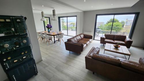 a living room with couches and a dining room with a table at Villa Ker Bunk in Audierne