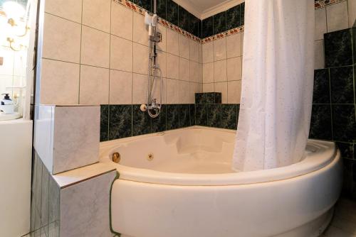 a bathroom with a tub and a toilet and a shower at Villa Sofia Nea Peramos in Néa Péramos
