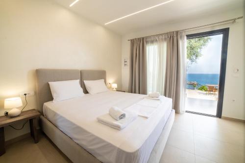 a bedroom with a large bed with a view of the ocean at Lithitsa Lofts and Suites in Parga