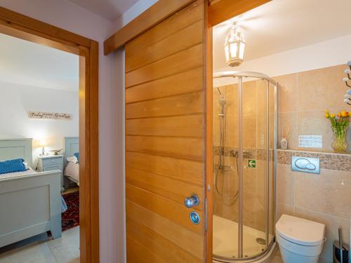 a bathroom with a shower and a wooden door at Villa Benka, Istrian stone house in Tinjan