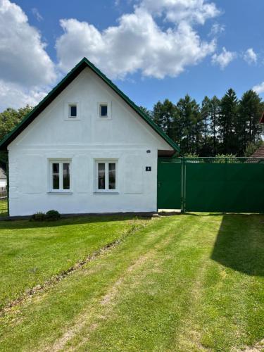 a white house with a green fence in a yard at Chalupa Františkov 