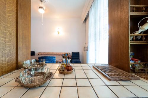 a kitchen with a tiled counter with baskets on it at Villa Sofia Nea Peramos in Néa Péramos