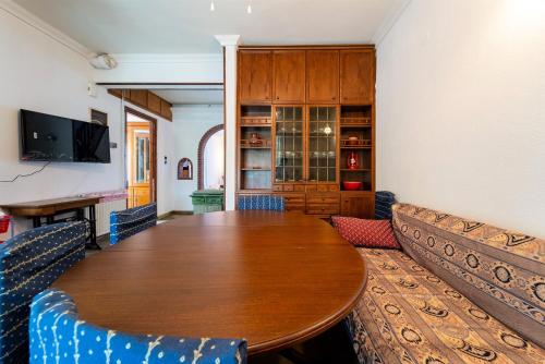 a dining room with a wooden table and chairs at Villa Sofia Nea Peramos in Néa Péramos