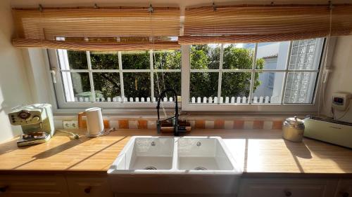 a kitchen with a sink and a large window at Lovely Beach House with Stunning View in Sesimbra