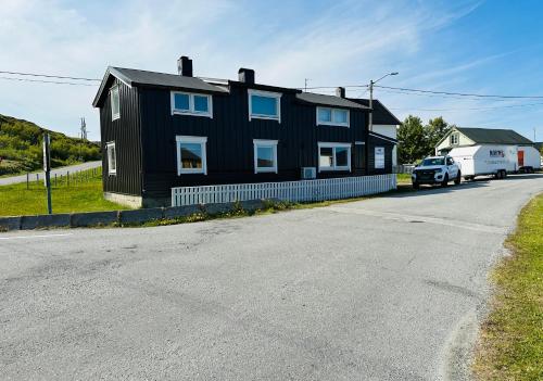 a black house on the side of a road at Bugøynes in Bugøynes