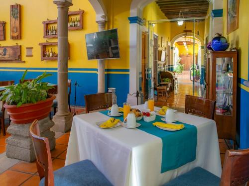 a table in a restaurant with a blue and yellow wall at La Casa de los Patios Hotel & Spa in Sayula