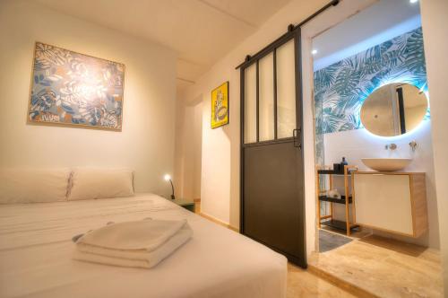 ein Schlafzimmer mit einem Bett mit einem Waschbecken und einem Spiegel in der Unterkunft Gunlayer Maisonette in Floriana
