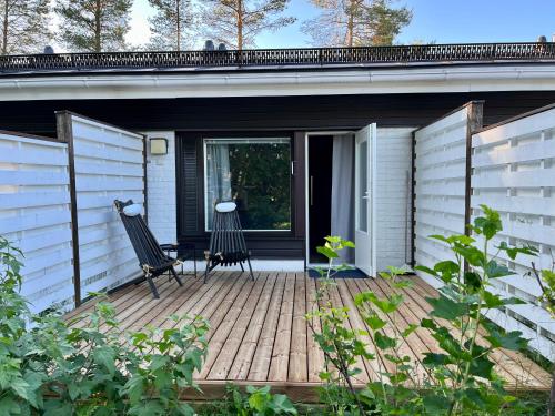 a porch with two chairs on a wooden deck at Townhouse with SAUNA&FREE PARKING close to Santa Claus Village & Santa Park in Rovaniemi