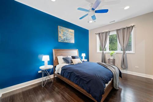 Spacious Luxury Retreat 8 Bed Oasis with 6 Baths في شيكاغو: غرفة نوم زرقاء مع سرير ومروحة سقف