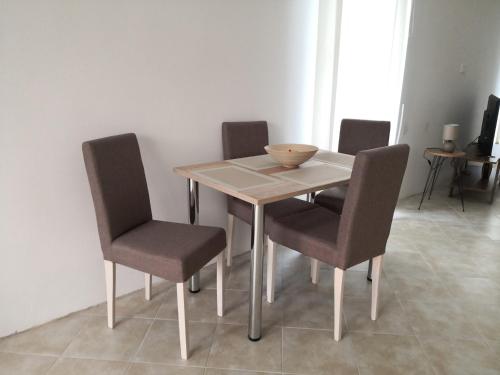 a dining room table with chairs and a bowl on it at Apartman MAJ in Bijelo Polje