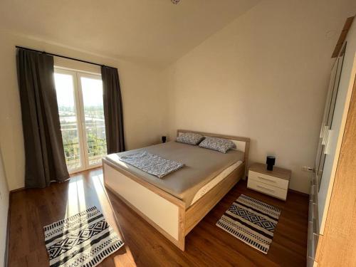 a bedroom with a bed and a large window at Apartments Majić in Kaštela