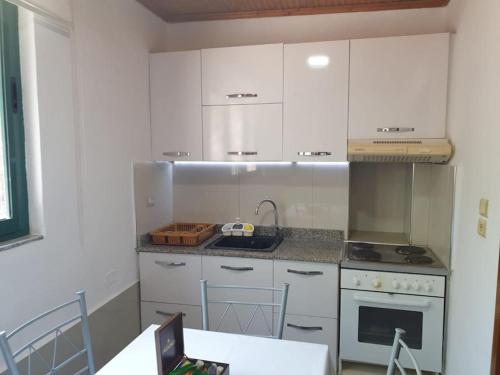 uma cozinha com armários brancos e uma bancada em Center Lake House em Shkodër