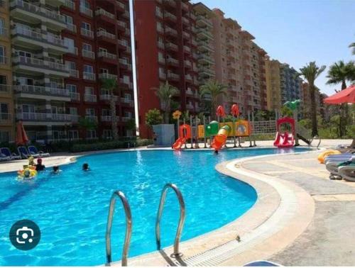 a swimming pool with a playground in a apartment complex at استديو فى بورتو جولف مارينا in El Alamein