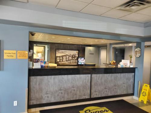 an office lobby with a reception desk and a counter at Super 8 by Wyndham Edmonton International Airport in Leduc