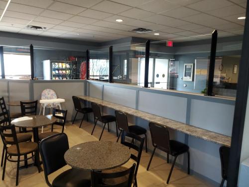 a bar with tables and chairs in a restaurant at Super 8 by Wyndham Edmonton International Airport in Leduc