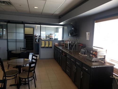 a kitchen with a table and some chairs and a counter at Super 8 by Wyndham Edmonton International Airport in Leduc