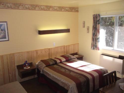 una camera da letto con un letto e una finestra di Auberge Mountain View Inn a Mont-Tremblant