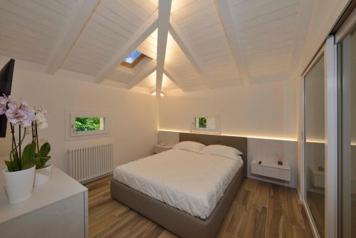 sypialnia z białym łóżkiem w pokoju w obiekcie Grenier Blanc - Appartamento a mansarda. w mieście San Pietro in Casale