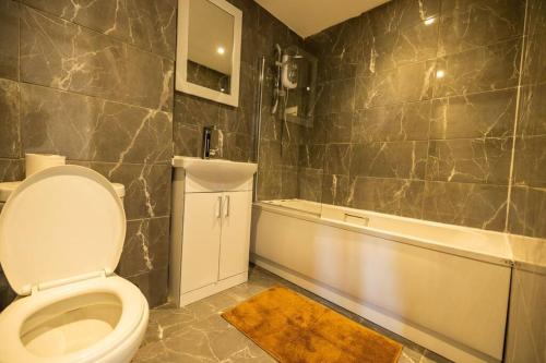 a bathroom with a toilet and a bath tub at PristineRelocation Accommodation in London