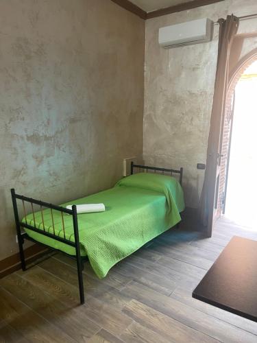 1 dormitorio con 1 cama verde en una habitación con ventana en The New B&B, en Poggio Imperiale