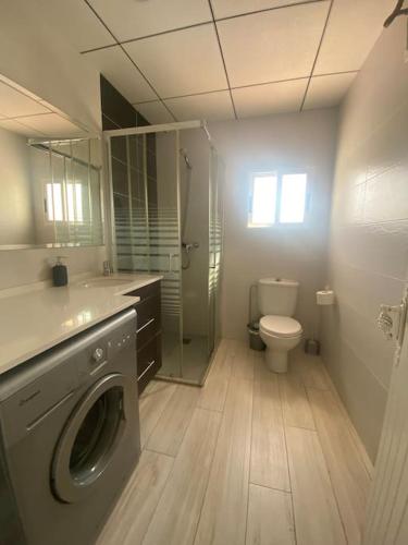 a bathroom with a washing machine and a toilet at VILLA PHILIP Piscina privada in Miami Platja