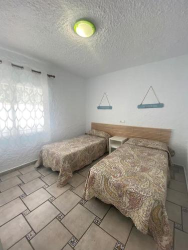 a bedroom with two beds and a tiled floor at VILLA PHILIP Piscina privada in Miami Platja