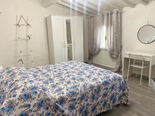 1 dormitorio con cama, mesa y espejo en La Petite Maison, en Usigliano