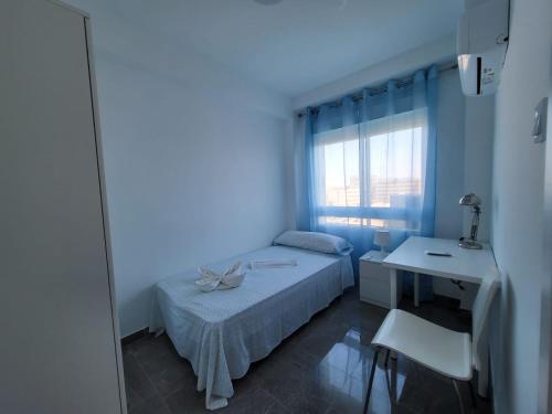 a bedroom with a bed and a desk and a window at Dreams Carthago in Cartagena
