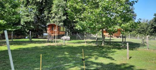 un parc avec un arbre et une maison dedans dans l'établissement Chalet du trappeur, à Grosbreuil