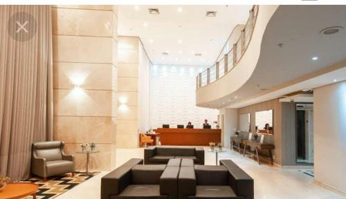 a large living room with a couch and chairs at Golden Flat's - Slaviero Guarulhos in Guarulhos