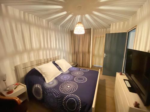 une chambre avec un lit et une télévision à écran plat dans l'établissement Chambre douillette, calme, lit queen size wifi, à Avrillé