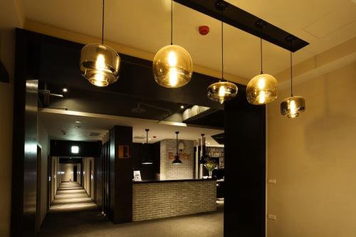 un couloir avec plusieurs lumières suspendues au plafond dans l'établissement Queens Hotel II, à Taipei