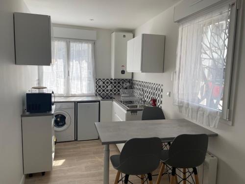 Una cocina con una mesa y cuatro sillas. en Studio récent, entièrement équipé, proche Chantiers et Airbus, en Saint-Nazaire