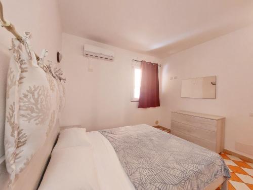 1 dormitorio con cama y jarrón en Casa di Agnese, en Alghero
