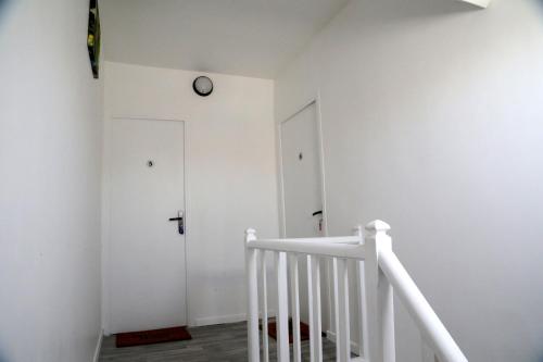 a white staircase with a clock on the wall at Mars in Saint-Quentin