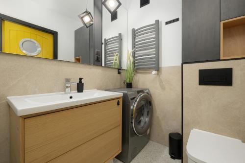 a bathroom with a washing machine and a sink at Grey Apartament - Dziwnów - Basen - SPA - Parking- Taras in Dziwnów