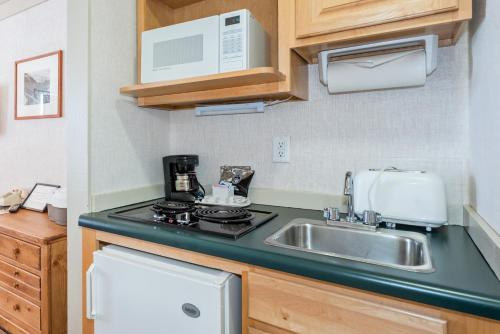 a kitchen with a sink and a microwave at Mountainside Inn 308 Hotel Room in Telluride