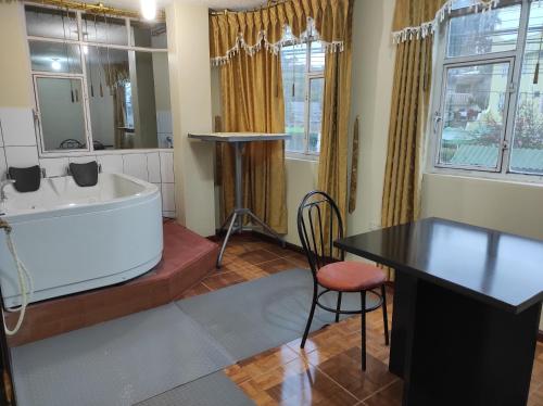 y baño con bañera, mesa y silla. en HOTEL CARIBEAN REAL en Latacunga