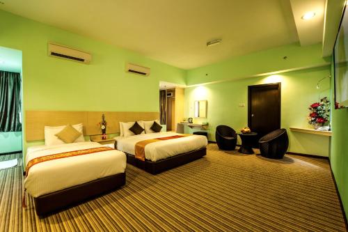 a hotel room with two beds and a desk at Thy Executive Hotel in Johor Bahru