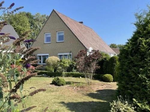 una casa con un jardín paisajista delante de ella en Gemütliches Ferienhaus, viel Platz in der Nähe der schönsten Ostseestrände, en Oldenburg in Holstein