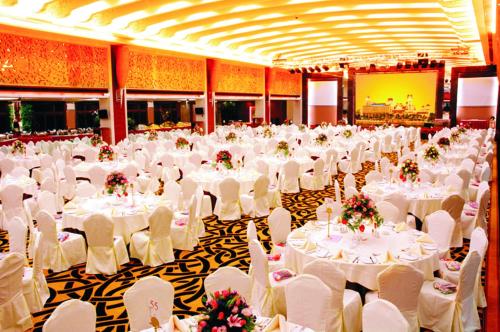 a large banquet hall with white tables and chairs at Dongguan Richwood Garden Hotel in Dongguan