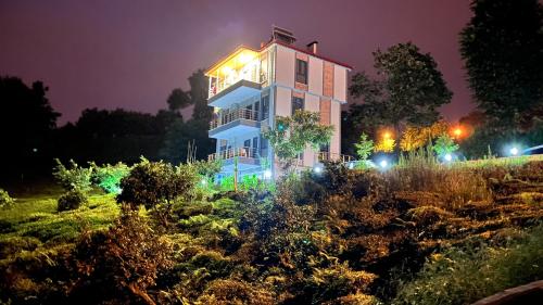 a building with lights in a garden at night at Noğa Suit Apart in Pazar